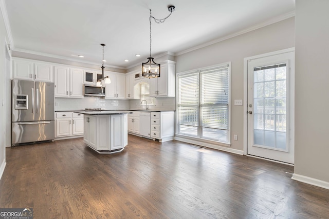 kitchen featuring white cabinets, appliances with stainless steel finishes, hanging light fixtures, and dark wood-type flooring