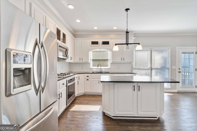 kitchen featuring hanging light fixtures, white cabinets, stainless steel appliances, dark hardwood / wood-style floors, and sink