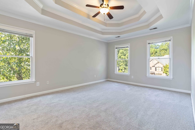 empty room featuring crown molding, carpet flooring, ceiling fan, and a wealth of natural light