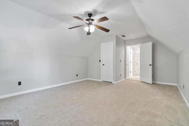 bonus room with lofted ceiling, ceiling fan, and light colored carpet