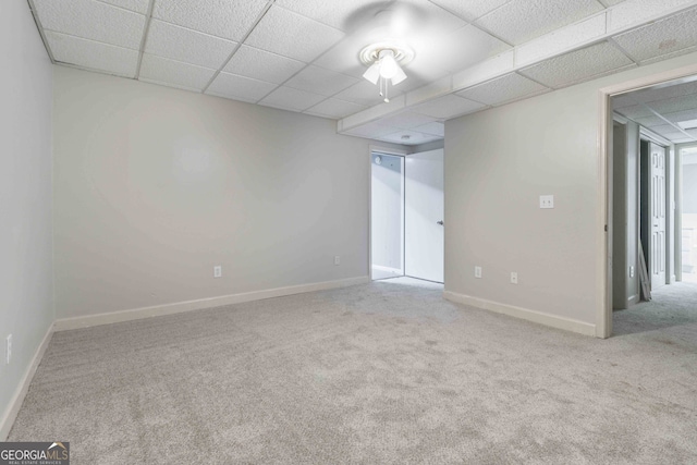 empty room with light colored carpet and a paneled ceiling