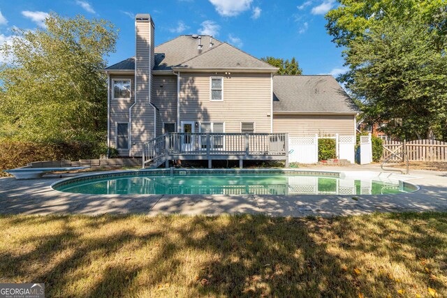 view of swimming pool with a wooden deck and a yard