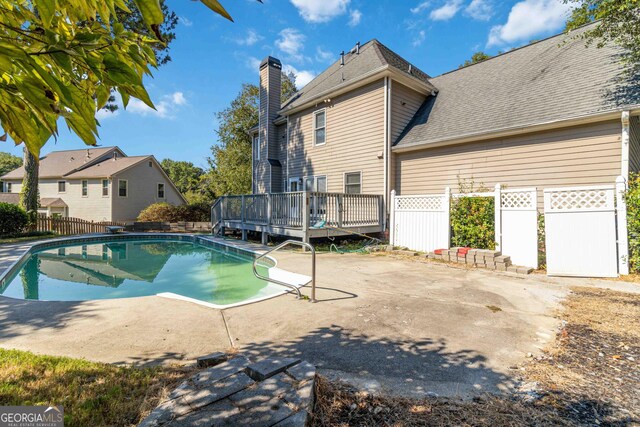 view of pool with a wooden deck and a patio area