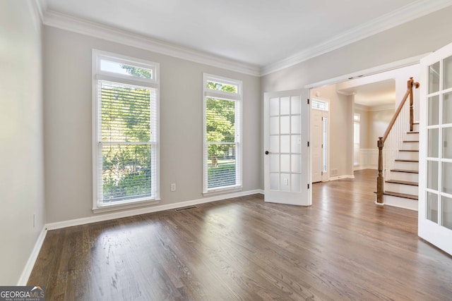 empty room with ornamental molding, dark hardwood / wood-style flooring, and french doors