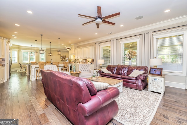 living room featuring light wood-type flooring, crown molding, and ceiling fan