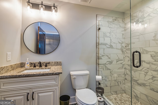 bathroom with vanity, walk in shower, and toilet