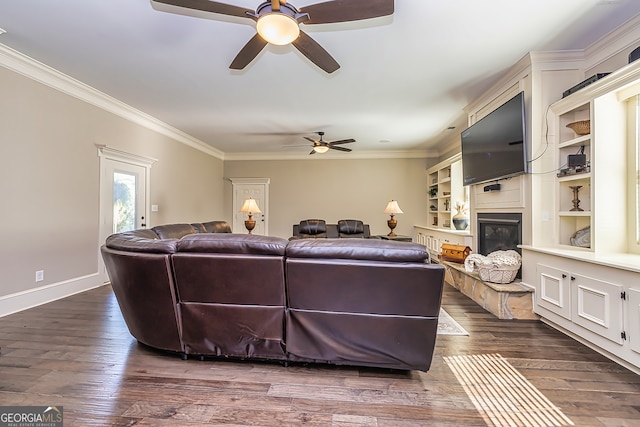 living room with ornamental molding, ceiling fan, dark wood-type flooring, and built in features