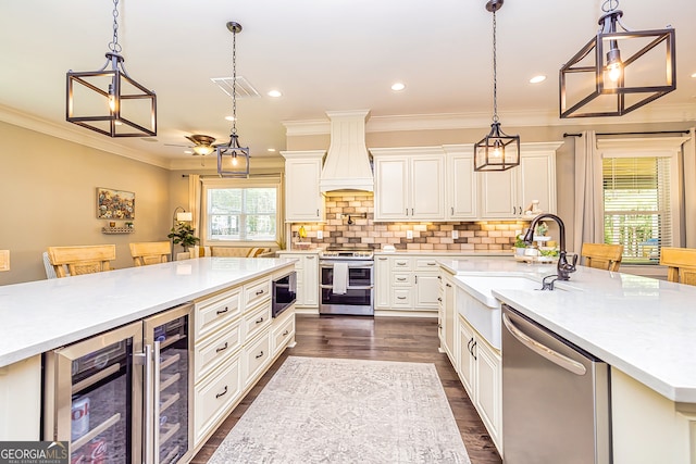 kitchen featuring premium range hood, beverage cooler, dark hardwood / wood-style flooring, appliances with stainless steel finishes, and decorative light fixtures