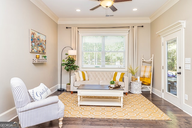 living area with crown molding, a wealth of natural light, and hardwood / wood-style floors