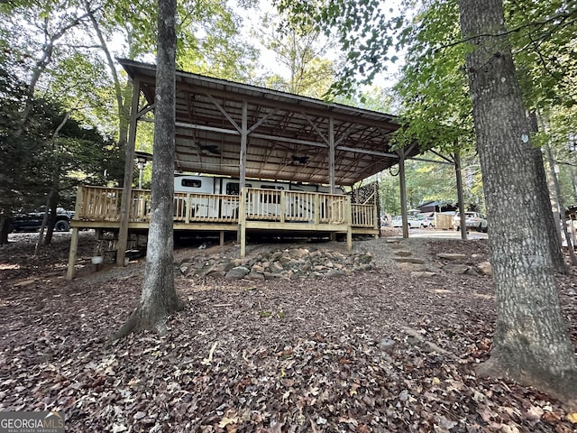 back of house featuring ceiling fan and a wooden deck