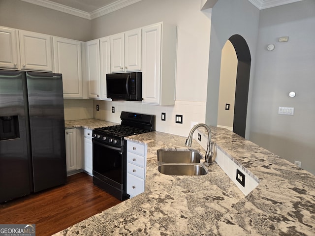 kitchen featuring light stone counters, sink, white cabinetry, black appliances, and crown molding