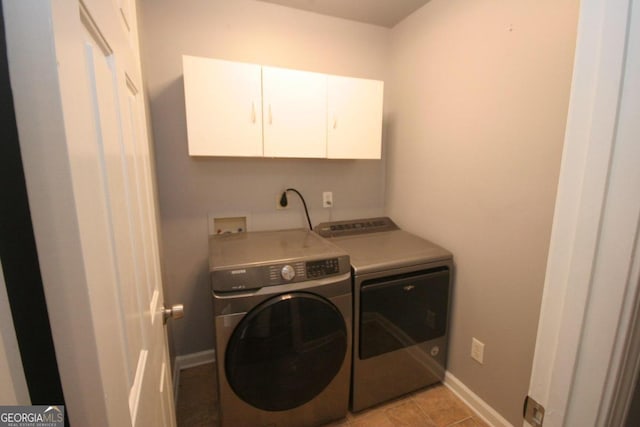 laundry room with light tile patterned flooring, separate washer and dryer, and cabinets