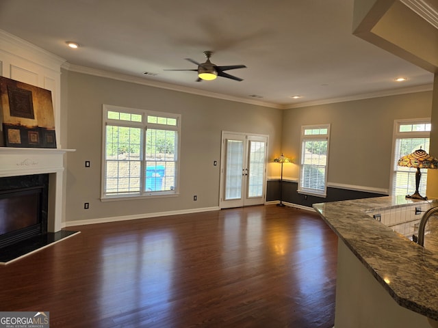 unfurnished living room with dark wood-type flooring, crown molding, and ceiling fan