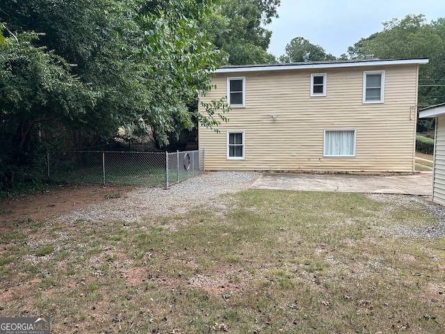 rear view of property featuring a lawn and a patio area