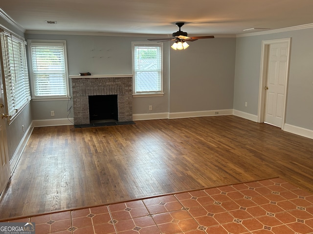 unfurnished living room featuring hardwood / wood-style flooring, ceiling fan, a brick fireplace, and plenty of natural light