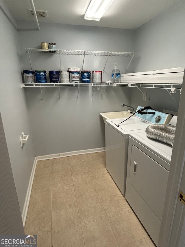 clothes washing area featuring washing machine and clothes dryer and light tile patterned floors