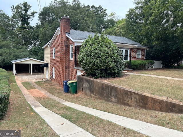 view of side of home featuring a lawn and a carport