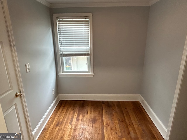 empty room with crown molding and hardwood / wood-style floors