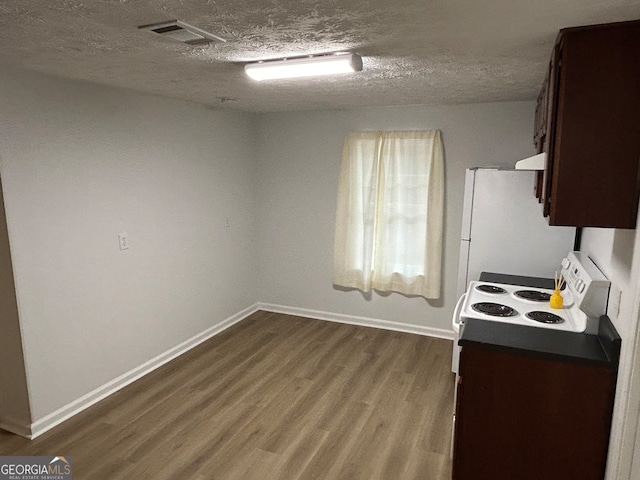 kitchen featuring dark brown cabinets, a textured ceiling, dark hardwood / wood-style floors, and white appliances