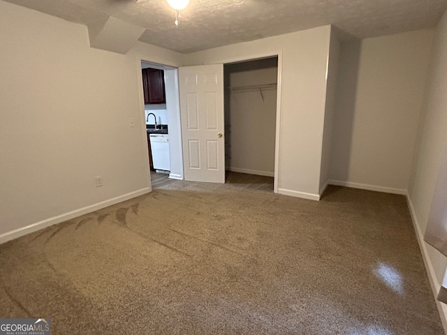 unfurnished bedroom featuring a textured ceiling, sink, and a closet