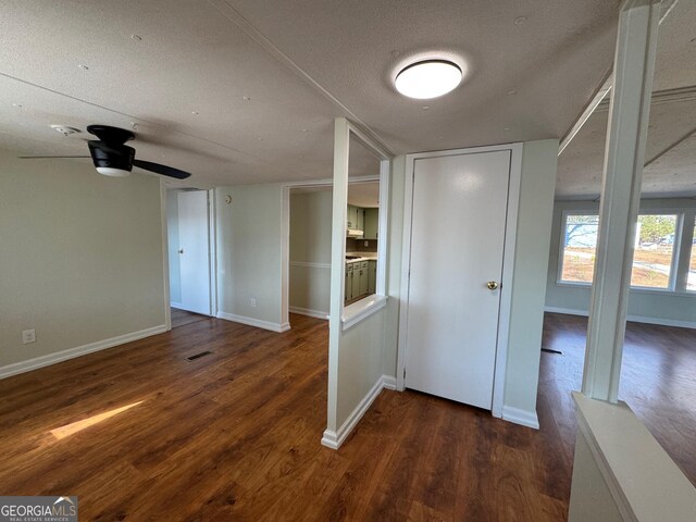 corridor featuring dark hardwood / wood-style flooring and a textured ceiling