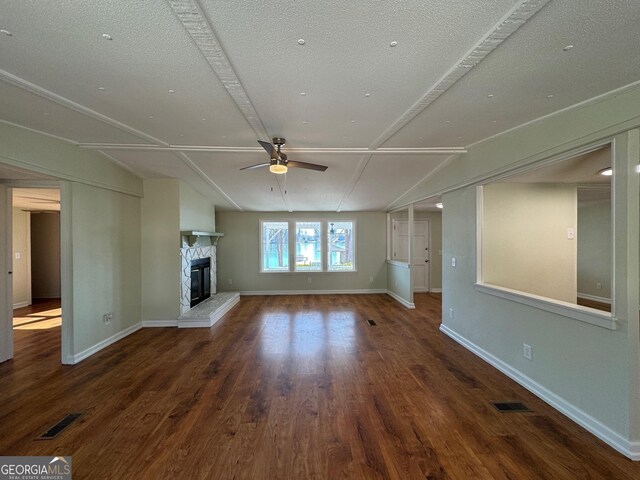 unfurnished living room with dark wood-type flooring, ceiling fan, and a fireplace