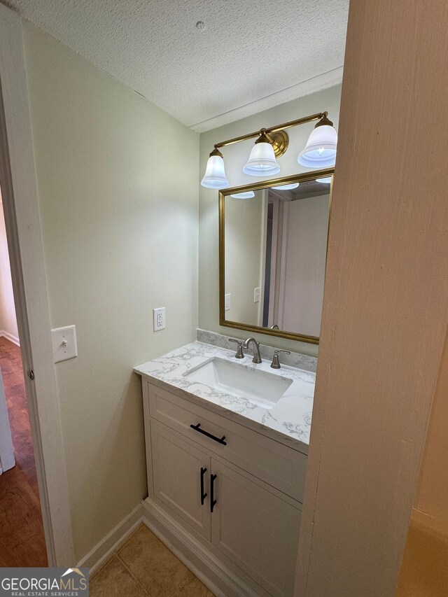 bathroom featuring vanity, tile patterned floors, and a textured ceiling