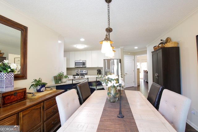 dining room with a textured ceiling, crown molding, and wood-type flooring