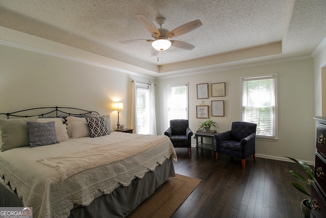 bedroom featuring ceiling fan, a raised ceiling, dark wood-type flooring, and multiple windows