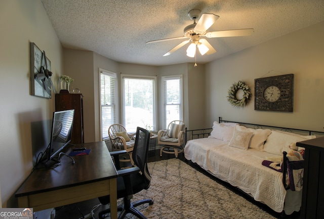 bedroom featuring ceiling fan and a textured ceiling