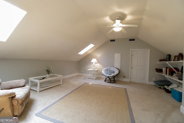 interior space with lofted ceiling with skylight, carpet flooring, and ceiling fan