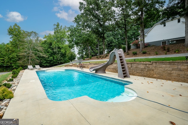 view of swimming pool featuring a patio and a water slide