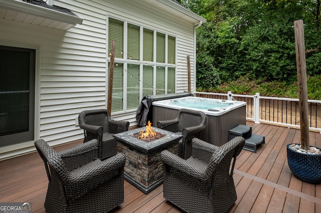 deck with a hot tub and a fire pit