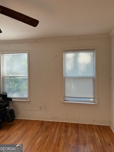 empty room with ornamental molding and light hardwood / wood-style floors