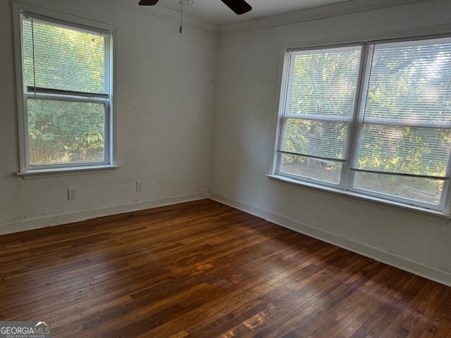 unfurnished room featuring ceiling fan, crown molding, and dark hardwood / wood-style flooring