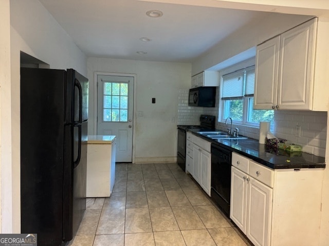 kitchen featuring tasteful backsplash, white cabinets, light tile patterned floors, black appliances, and sink