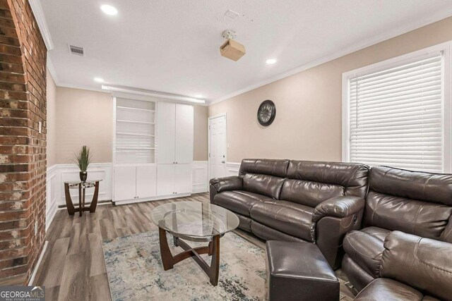 living room featuring wood-type flooring and crown molding