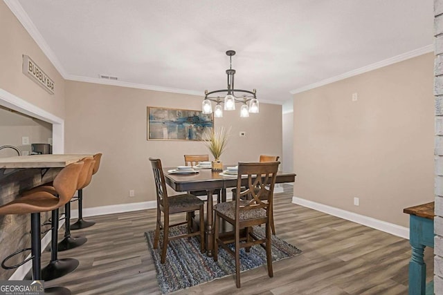 dining space with a notable chandelier, dark hardwood / wood-style floors, and crown molding