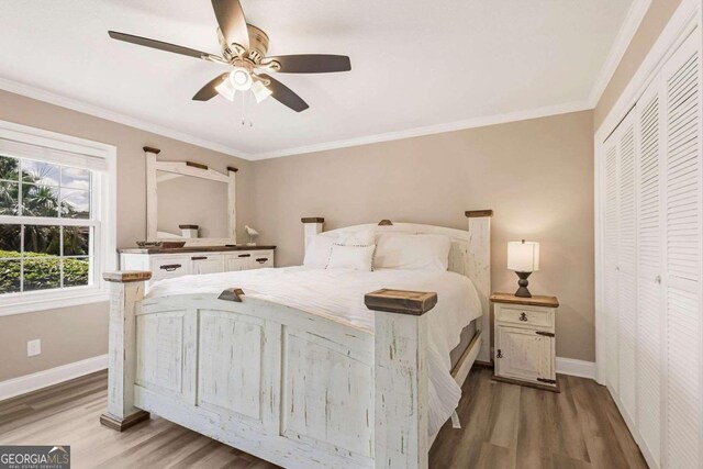 bedroom featuring ornamental molding, dark hardwood / wood-style floors, ceiling fan, and a closet