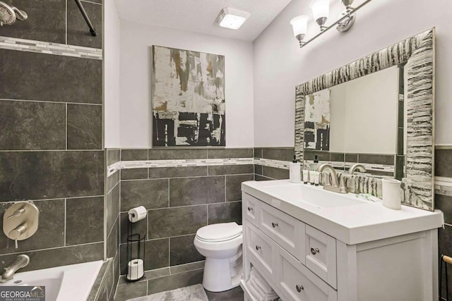 bathroom with tile walls, tile patterned flooring, a textured ceiling, vanity, and toilet