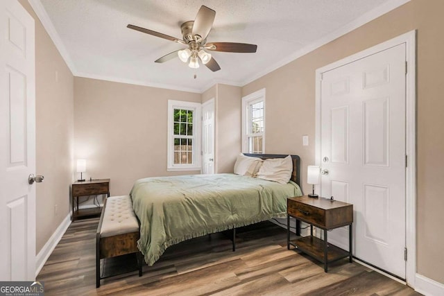 bedroom with a textured ceiling, ornamental molding, hardwood / wood-style floors, and ceiling fan