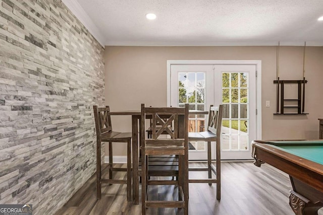 interior space featuring a textured ceiling, ornamental molding, billiards, and hardwood / wood-style flooring