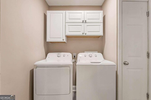 clothes washing area featuring cabinets and washer and dryer