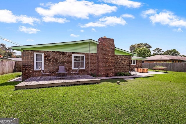 rear view of property featuring a wooden deck, a patio area, and a yard