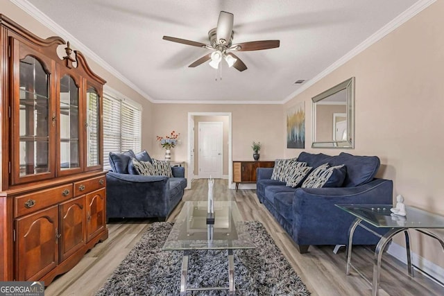 living room with ornamental molding, ceiling fan, and light hardwood / wood-style flooring