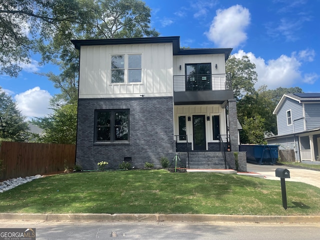 view of front facade featuring a balcony and a front yard