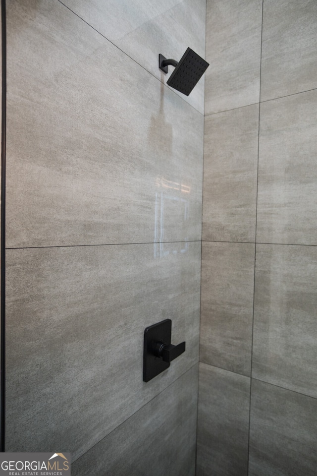 interior details featuring tiled shower