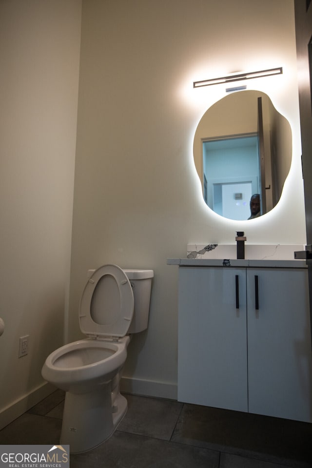 bathroom with tile patterned flooring, vanity, and toilet