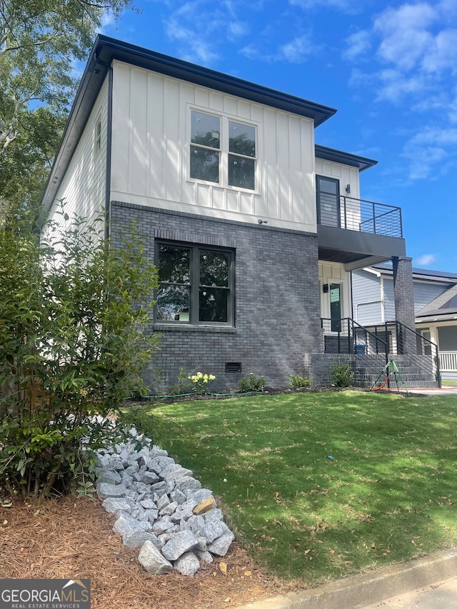 view of front facade featuring a balcony and a front lawn