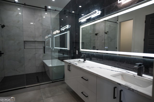 bathroom featuring tile walls, tile patterned floors, a shower with door, and vanity